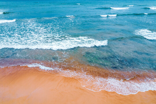 Beautiful background of sea with fine waves and yellow sand, mood before storm, aerial top view