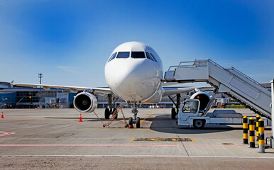 Boarding passengers on the plane. Boarding bridge. The plane lands at the international airport. Loading luggage. White airplane. Terminal Runway. Copy space