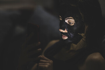 a woman cleaning her skin while looking at her phone