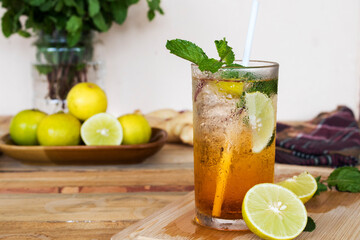 herbal healthy drinks cold lemon tea for health care with peppermint leaf and lemon slice on background wooden
