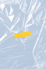 Yellow tape on a wrinkled plastic wrap textured background