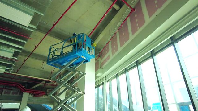 Kuala Lumpur, Malaysia - 15 April 2021   modern hydraulic scissors lift going down in light spacious shopping mall hall.
