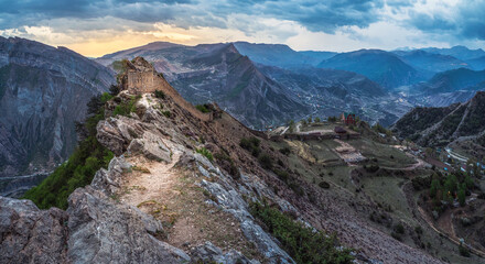 Dramatic sunrise at the ancient fortress on the top of the mountain. The Gunib fortress is a historical monument of Dagestan.