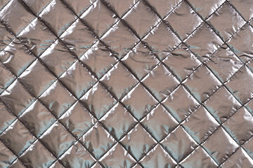 surface of a silvery jacket fabric with padding polyester, background, texture