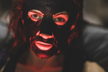 portrait of a masked woman in red light