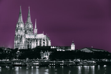 Fototapeta premium Cologne, Germany. Night View Of Cologne Cathedral. Catholic Gothic Cathedral In Night. UNESCO World Heritage Site. Toned Photo Black, White And Ultra Violet Colors