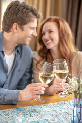 Man and woman touching glasses with each other