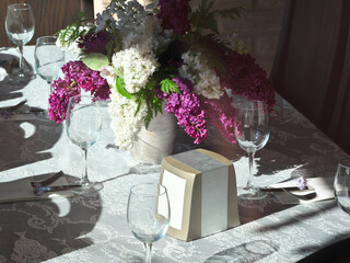 A bouquet of lilacs is in a vase on the table.