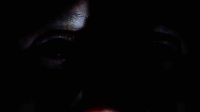 Close up mysterious eye in the night with chiaroscuro, freezing and frightening atmosphere, creepy man's face hidden in the dark, spy eye 