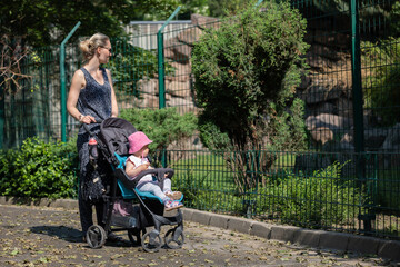 Mutter schaut sich mit ihrem Kind die Tiere im Zoo an