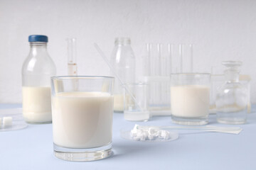 Laboratory glassware, bottles and glasses of milk.Testing milk quality and lactose forms - obrazy, fototapety, plakaty