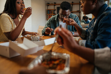 Young happy friends having fun during lunchtime at home