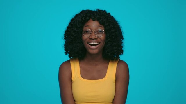 Surprised african woman saying wow over blue background