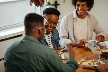 Young black friends eating take out food at home