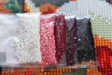 Multicolored diamond strases in container for handmade process of creation of diamond painting 3d