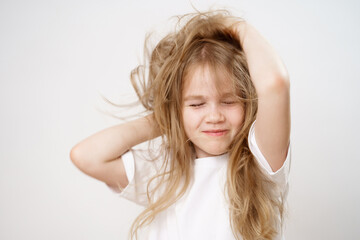 Naklejka premium woke up little girl with shaggy long hair on a white background