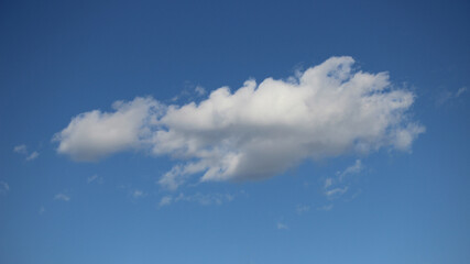 Naklejka na ściany i meble few little fluffy white clouds in blue sky in june