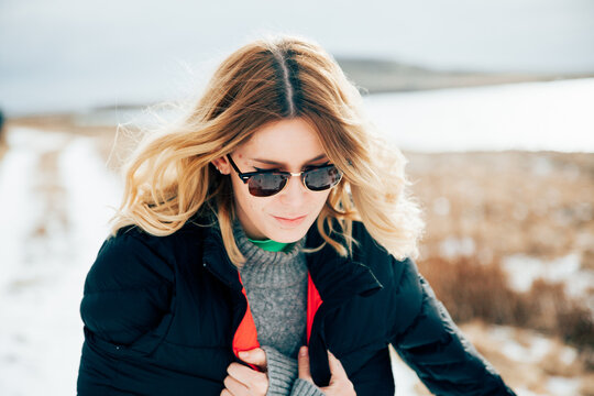 Freezing woman walking on snowy road