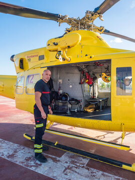 Rescuer standing by yellow helicopter