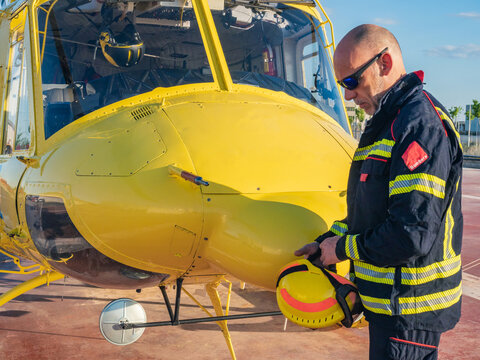 Rescuer standing by yellow helicopter