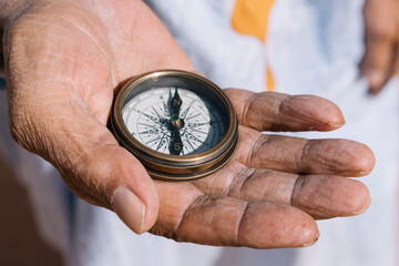 Crop person with compass in desert