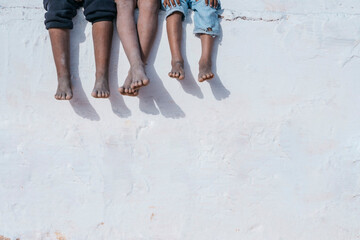 Legs of black children on white wall