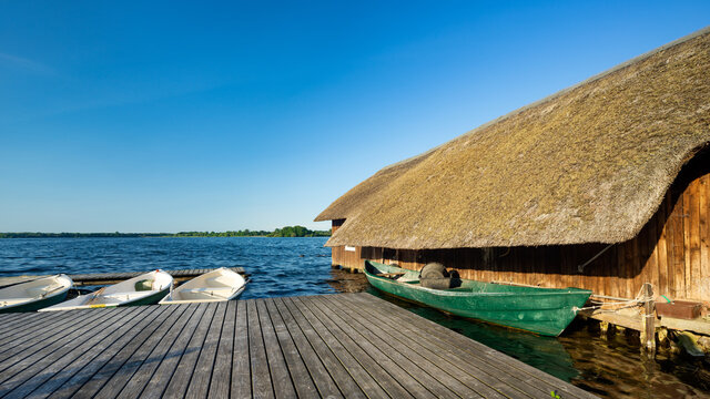 Reetgedecktes Bootshaus und Angelboote am Schaalsee