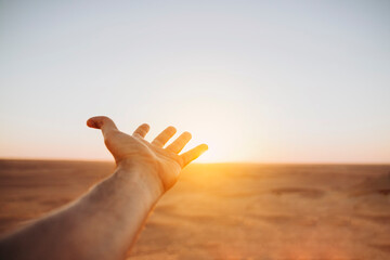 Open hand setting against the sunset sun