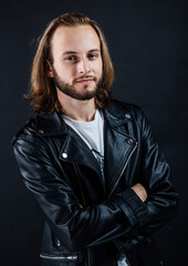 bearded rocker in leather jacket. man with long hair. rock style fashion. stylish brutal man hipster.