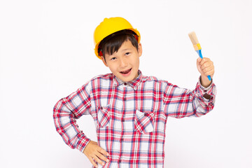 Little kid as a construction worker wearing yellow helmet with a paintbrush in his hand..White background studio picture.