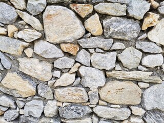 Stonewall. Wall made of stones. Garden wall.