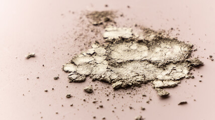 Fototapeta na wymiar broken eye shadow scattered across the smooth pink surface. Texture background, advertising the structure of cosmetics. macro, copyspace