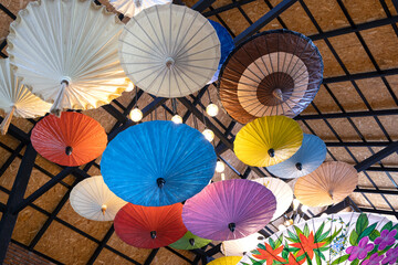 Beautiful and colorful handmade paper umbrellas on a ceiling.