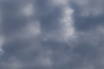 Fototapeta premium Dark gray clouds with light a little light shining through on a fall day in Germany.
