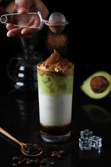 Ice fresh avocado juice combine with dalgona coffee and sprinkled chocolate powder 