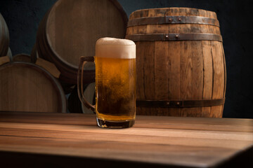 Oktoberfest beer barrel and beer glasses with wheat and hops on wooden table