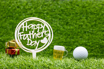 Naklejka premium Golf Father's Day with golf ball and sign are on green grass with beer