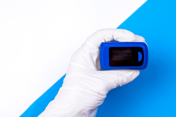 Doctors hand in white medical latex gloves hold pulse oximetry. Noninvasive and painless oxygen saturation level test. Part of set.