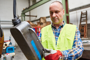 Worker at the control panel of a machine in a factory