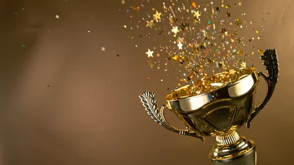Foto op Aluminium Champion golden trophy isolated on black background. Concept of success and achievement. Gold glitters explosion. © Lukas Gojda