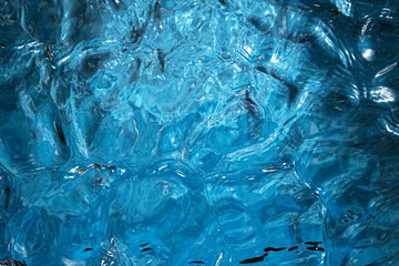 Obraz na płótnie Canvas Blue water surface background, studio shot, texture of splashing abstract water shape