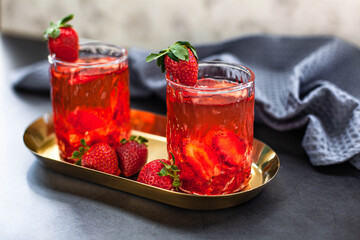 Red drink with ice and strawberry with leaves