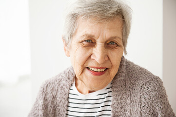 Portrait of a cheerful elderly woman with gray hair.