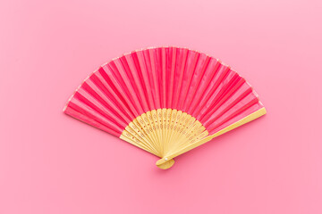 Pink open hand fan made of bamboo and paper. Top view