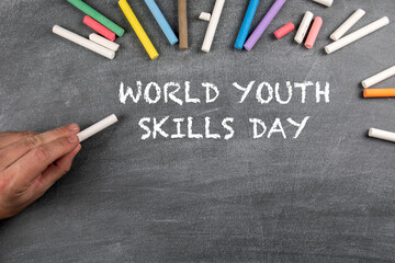 World Youth Skills Day 15 July. Colored pieces of chalk on a background of a dark chalk board
