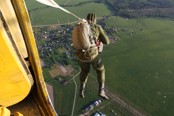 A paratrooper just jumped out of an airplane.