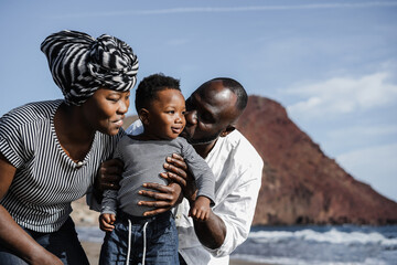 African family playing on the beach in summer vacation - Focus on mother face - Main focus on kid...