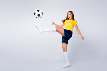 Full length body size view of nice beautiful purposeful sportive cheerful focused straight-haired girl playing football hitting ball having fun isolated over light white gray pastel color background