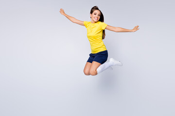 Fototapeta na wymiar Full size photo of cheerful professional soccer player girl jump enjoy play football world championship cup wear kit white socks shoes boots isolated over grey color background