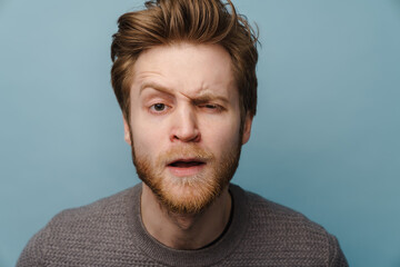 White ginger man with beard grimacing and looking at camera